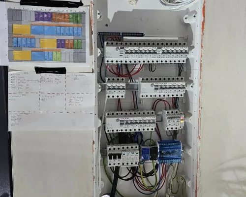 rozdzielnia budynkowa podczas montażu. Po lewej stronie podgląd rozmieszczenia aparatury w szafie oraz opisy obwodów